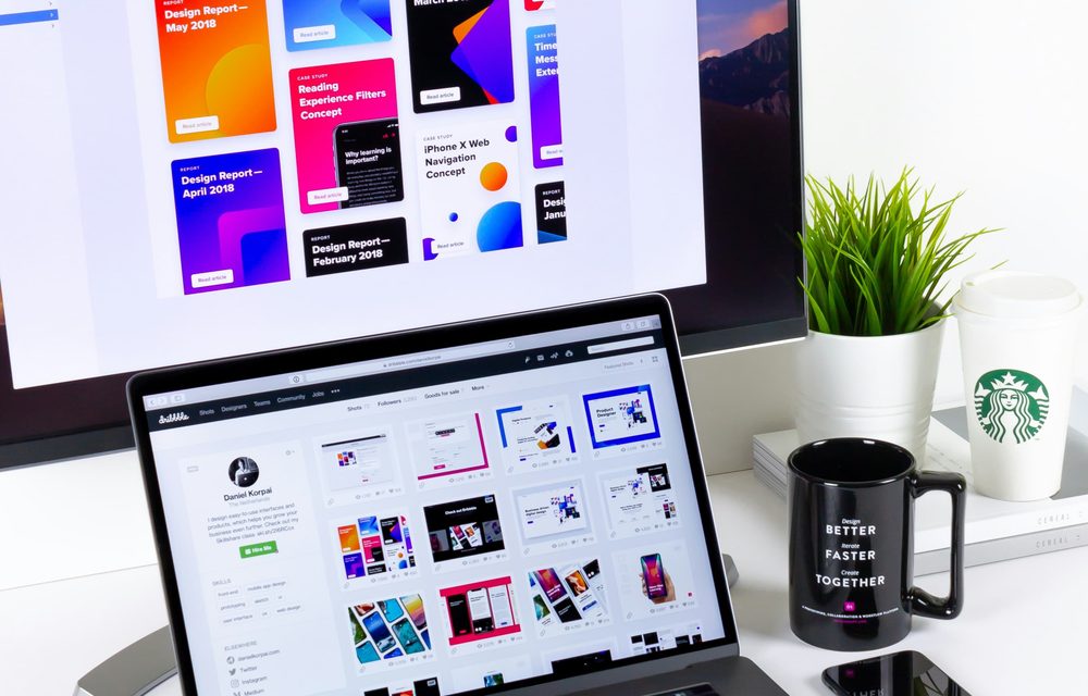 Escritorio de diseño con trabajos creativos en pantalla, representando el marketing digital